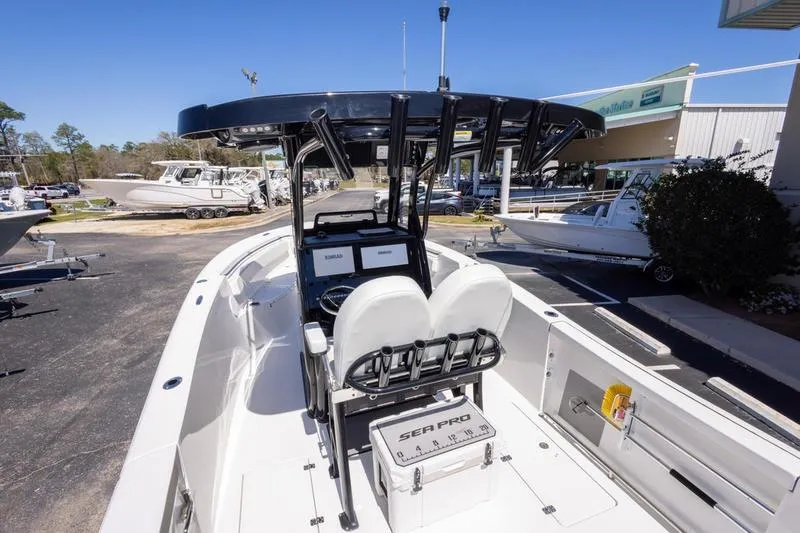 Slide: The Image of 2025 Sea Pro 262 Offshore boat interior with dual seats and console, docked outdoors. - 20