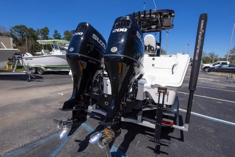 Slide: The Image of 2025 Sea Pro 262 Offshore boat with dual Suzuki 200 outboard engines in a parking lot. - 22