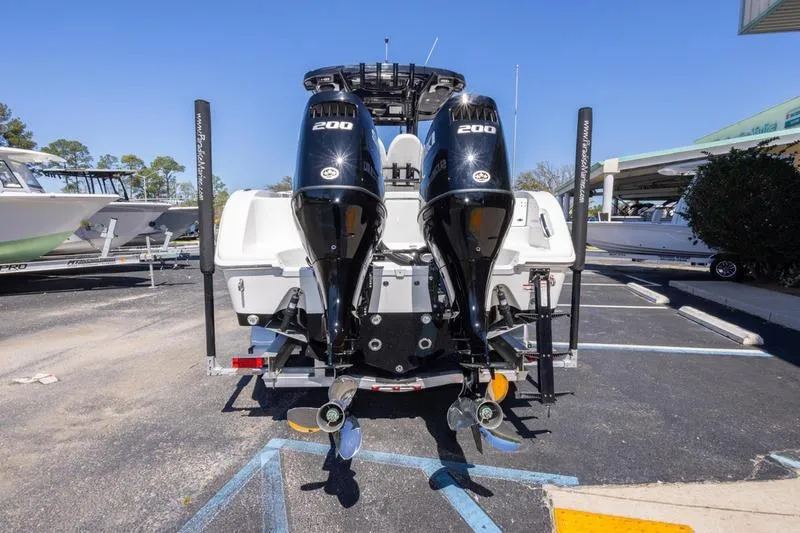 Slide: The Image of 2025 Sea Pro 262 Offshore boat with dual 200 horsepower engines, parked in a marina. - 23