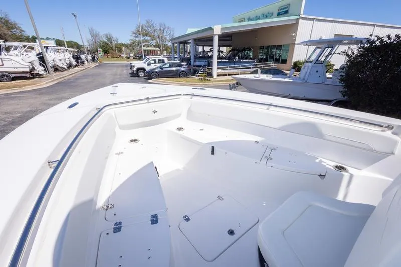Slide: The Image of 2025 Sea Pro 262 Offshore boat displayed at a dealership, showcasing spacious deck design. - 25