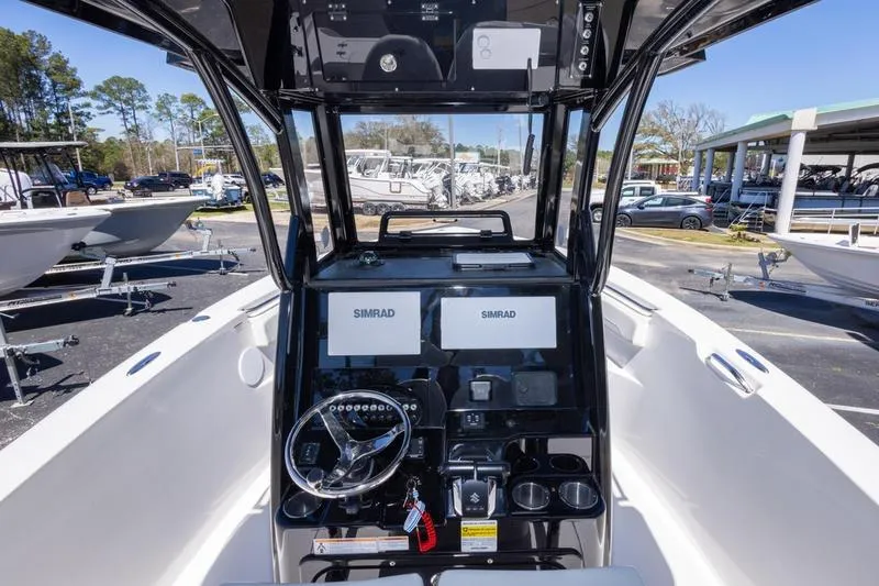 Slide: The Image of 2025 Sea Pro 262 Offshore boat dashboard with dual Simrad displays and steering wheel. - 26