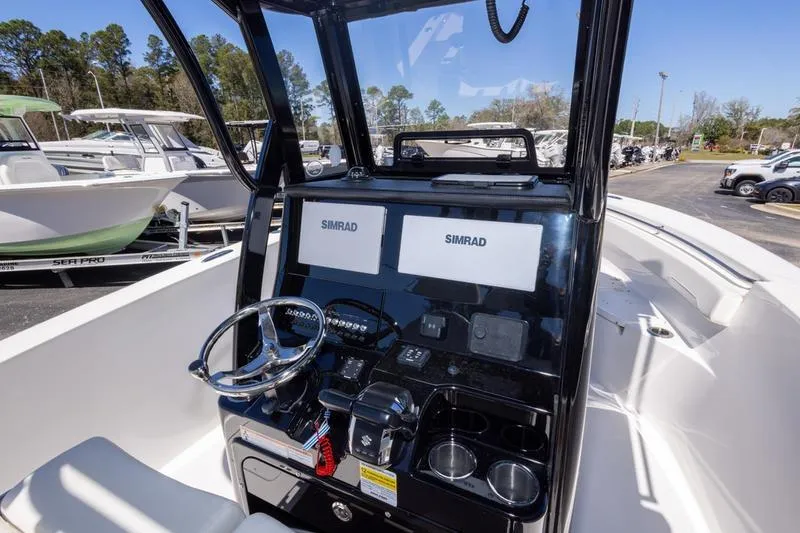 Slide: The Image of 2025 Sea Pro 262 Offshore boat dashboard with dual Simrad displays and steering wheel. - 27