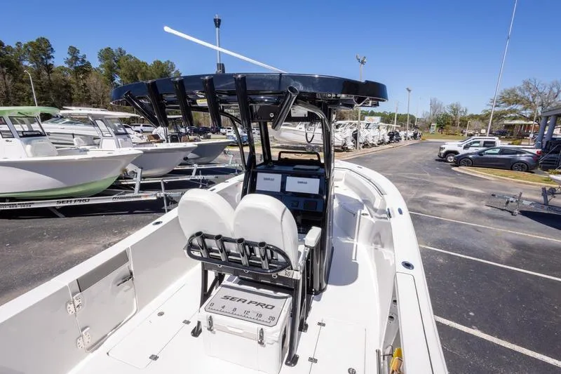 Slide: The Image of 2025 Sea Pro 262 Offshore boat with dual seats and modern console, parked outdoors. - 29