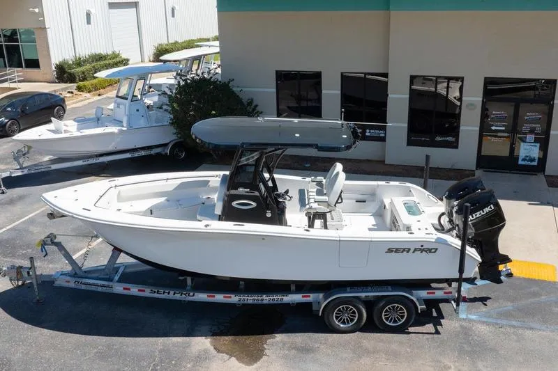Slide: The Image of 2025 Sea Pro 262 Offshore boat on trailer, parked outside a building. - 3
