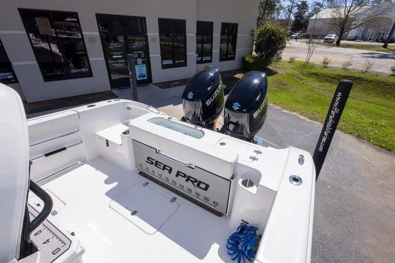 Slide: The Image of 2025 Sea Pro 262 Offshore boat with dual Suzuki engines, parked outside a building. - 31
