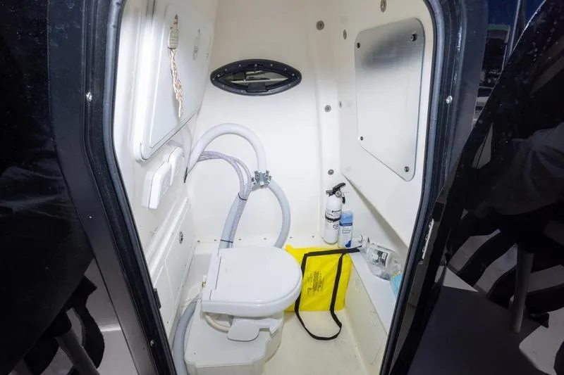 Slide: The Image of 2025 Sea Pro 262 Offshore boat interior with compact marine toilet and storage. - 34