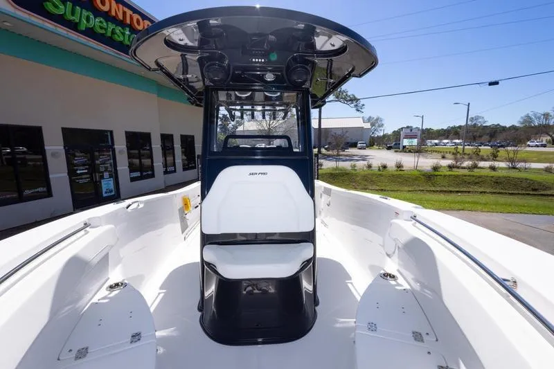 Slide: The Image of 2025 Sea Pro 262 Offshore boat interior with seating and console, displayed outdoors. - 37