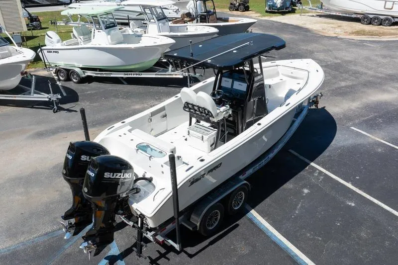 Slide: The Image of 2025 Sea Pro 262 Offshore boat with dual Suzuki engines on a trailer in a marina. - 9