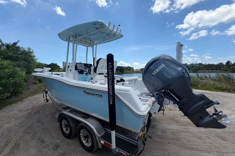 Slide: The Image of 2024 Tidewater 210 CC Adventure boat on trailer with Yamaha engine, parked near water. - 10