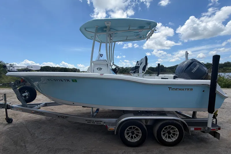 Slide: The Image of 2024 Tidewater 210 CC Adventure boat on trailer under a clear blue sky. - 11