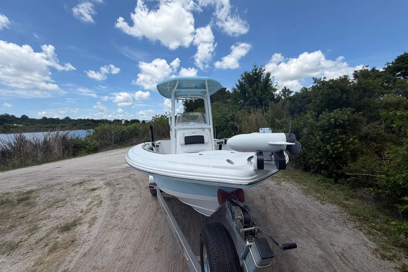 Slide: The Image of 2024 Tidewater 210 CC Adventure boat on trailer by a scenic lake. - 12