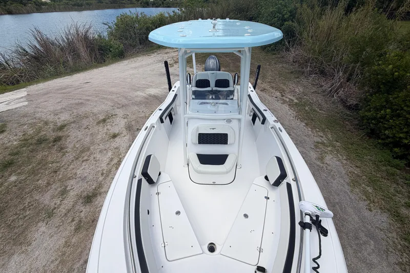 Slide: The Image of 2024 Tidewater 210 CC Adventure boat on a sandy shore near water. - 13