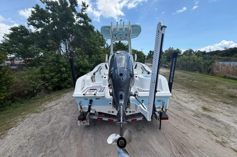 Slide: The Image of 2024 Tidewater 210 CC Adventure boat with outboard motor, parked on a grassy area. - 9