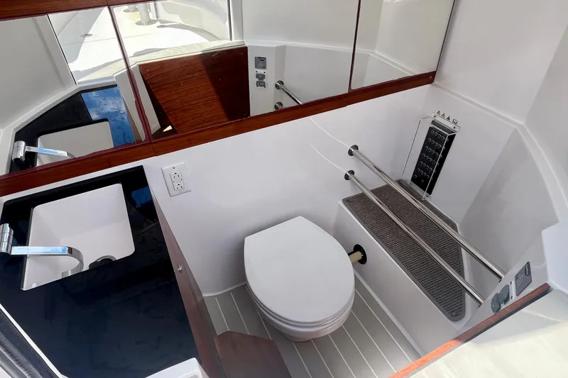 Slide: The Image of 2019 Axopar 28 Cabin bathroom with modern sink, toilet, and sleek design. - 11