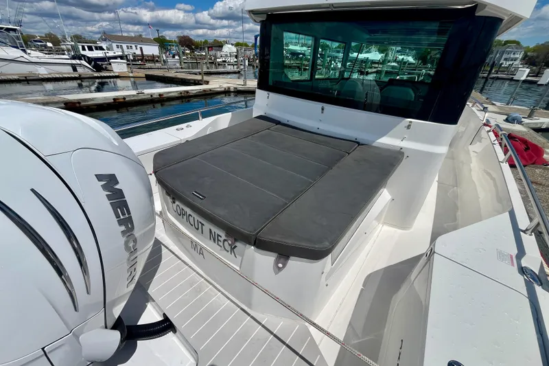 Slide: The Image of 2019 Axopar 28 Cabin boat docked, featuring a Mercury engine and spacious seating area. - 14
