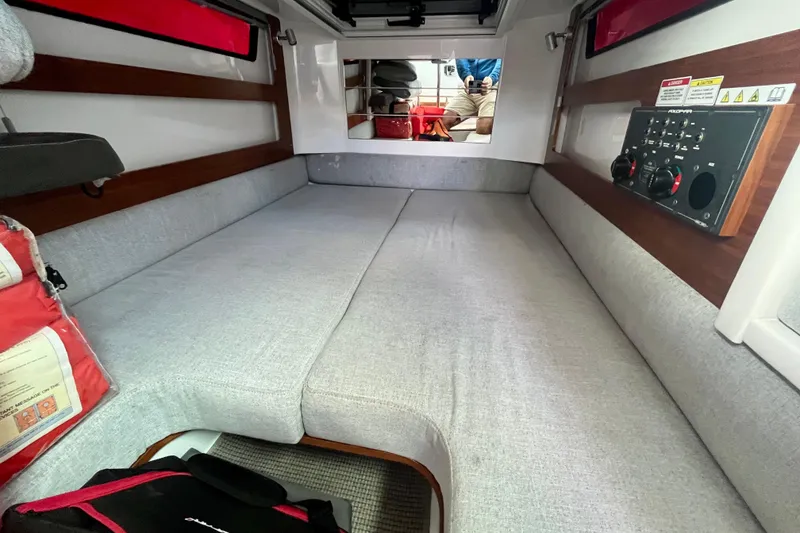 Slide: The Image of 2019 Axopar 28 Cabin interior with gray seating and control panel. - 15
