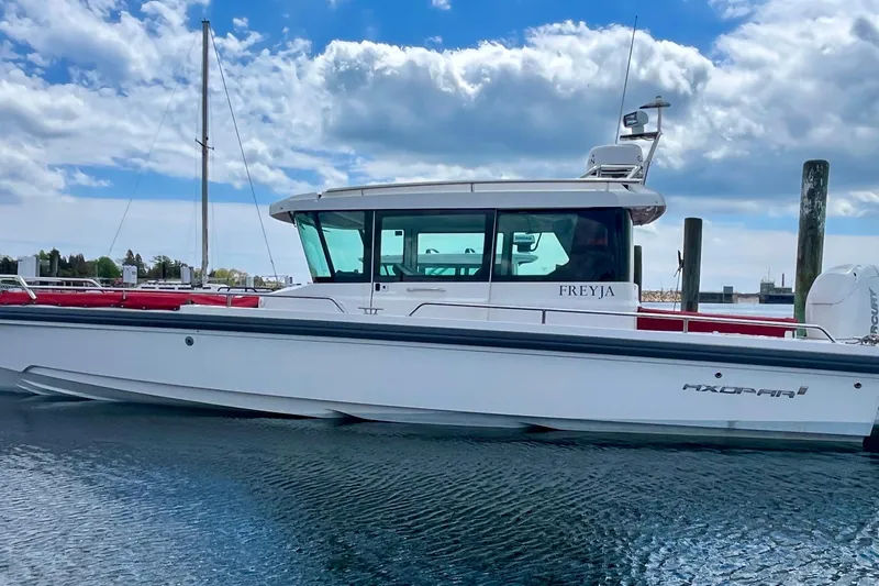 Slide: The Image of 2019 Axopar 28 Cabin boat docked on a sunny day with blue skies. - 18