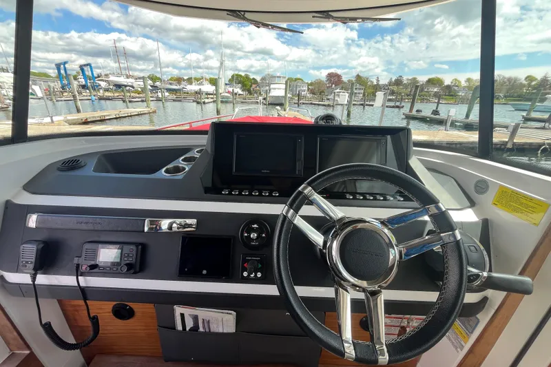 Slide: The Image of Interior view of 2019 Axopar 28 Cabin boat dashboard with steering wheel and controls. - 5