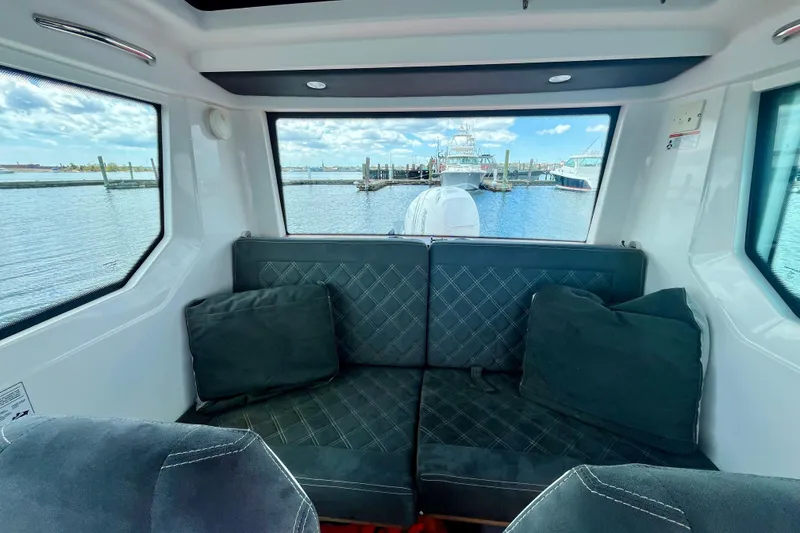 Slide: The Image of Interior view of 2019 Axopar 28 Cabin boat with waterfront scenery. - 7