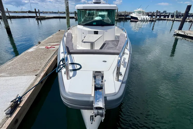 Slide: The Image of 2019 Axopar 28 Cabin boat docked at marina, featuring sleek design and spacious deck. - 9