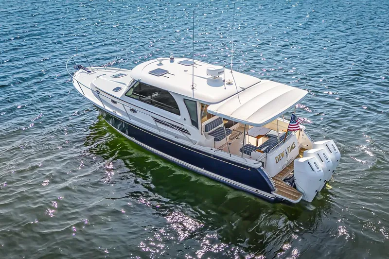 Slide: The Image of 2024 Back Cove 39O Downeast Style Yacht on water, featuring a sleek design and triple Mercury V-10 400 HP engines. - 2