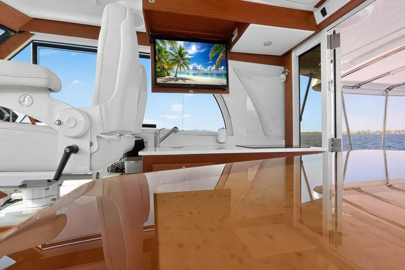 Slide: The Image of 2024 Back Cove 39O yacht interior with luxurious seating,  adjustable tabletop, modern galley and drop down smart TV - 21