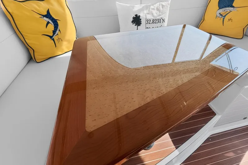 Slide: The Image of 2024 Back Cove 39O yacht interior with polished wooden table and decorative cushions. - 28