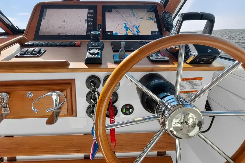 Slide: The Image of Helm of 2024 Back Cove 39O boat with navigation screens and controls. - 32