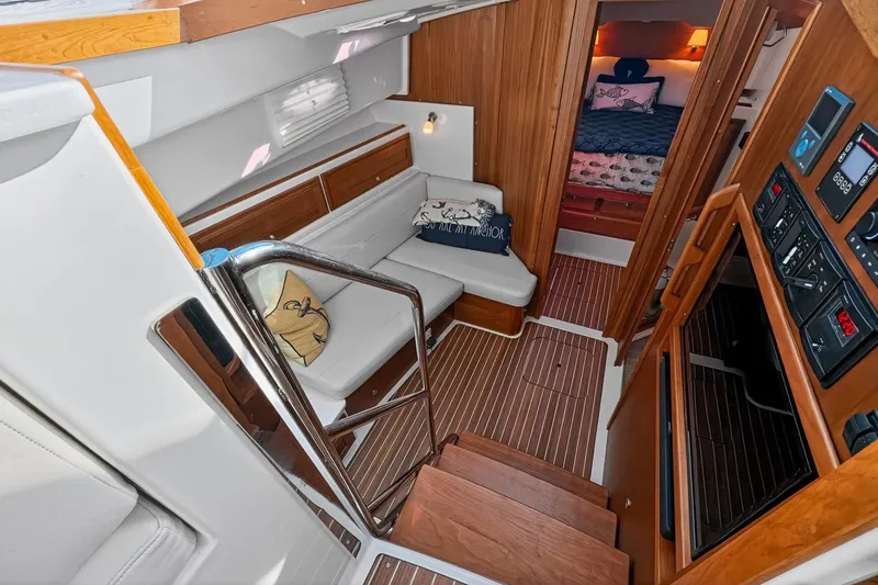 Slide: The Image of 2024 Back Cove 39O yacht lower deck  with cozy seating, wood accents, smart TV, control panels and access to a comfortable Owners cabin, Head and mid cabin - 55