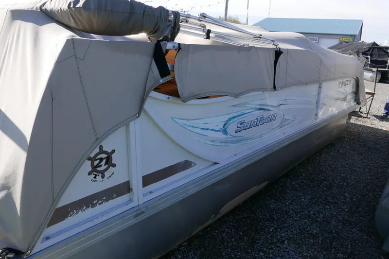 Slide: The Image of 2008 JC SunToon 21TT pontoon boat covered and parked on gravel. - 15