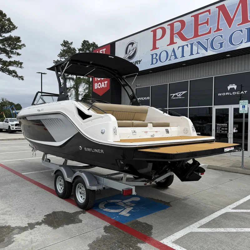 Slide: The Image of 2025 Bayliner D22I boat on trailer outside boating center. - 10