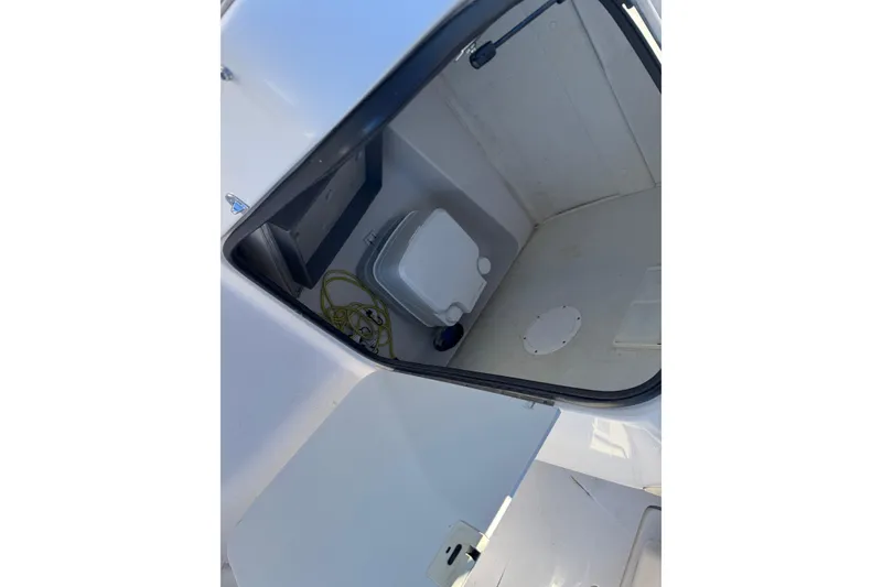 Slide: The Image of Interior of a 1997 Chaparral 232 Sunesta boat showing a compact toilet area. - 9