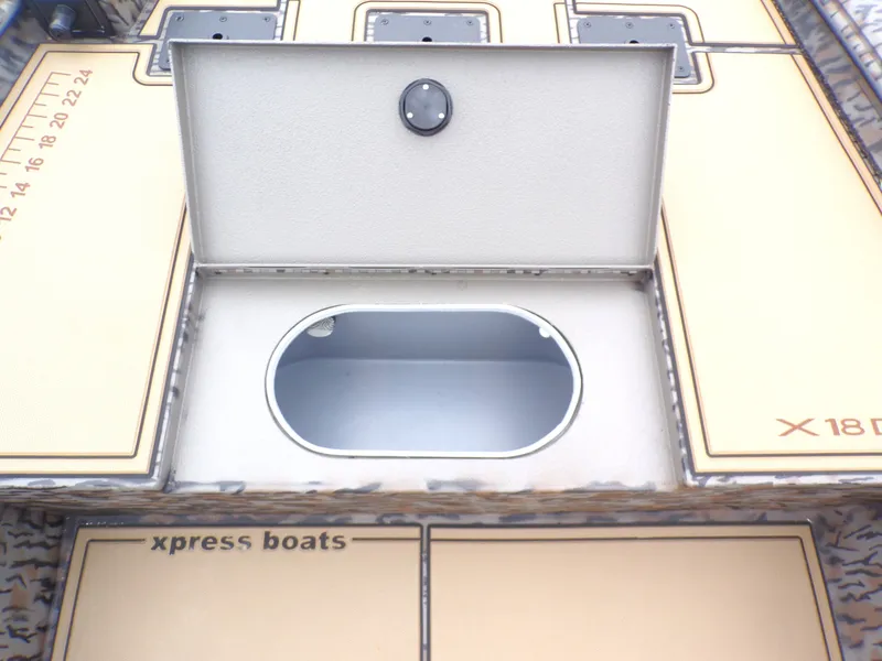 Slide: The Image of Xpress X18DB 2026 boat with open storage compartment and measuring scale. - 18