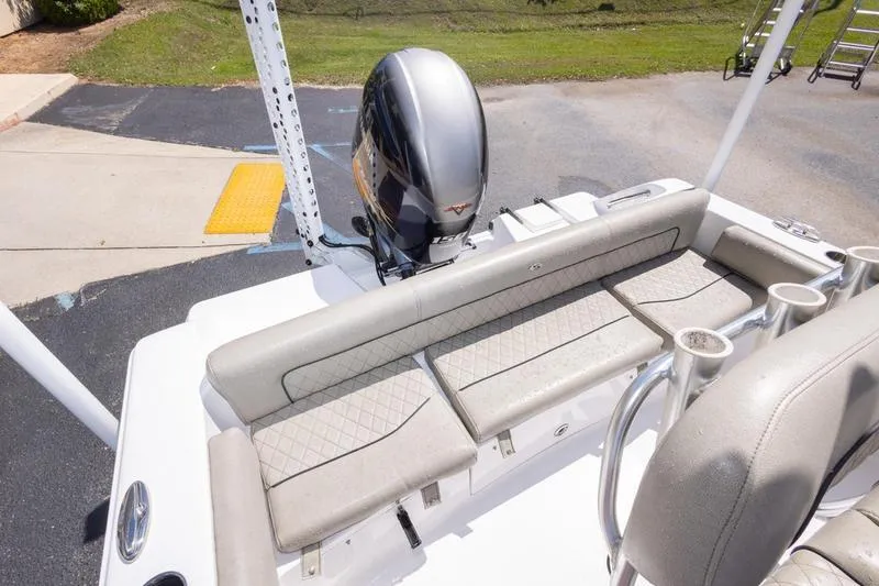 Slide: The Image of 2021 Sportsman Heritage 211 Center Console boat with cushioned seating and outboard motor. - 2