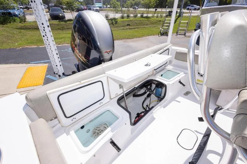 Slide: The Image of 2021 Sportsman Heritage 211 Center Console boat interior with storage compartments and engine view. - 5