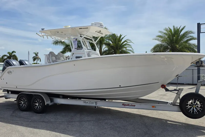 The Image of 2023 Sea Fox 288 Commander boat on trailer, palm trees in background. - 1