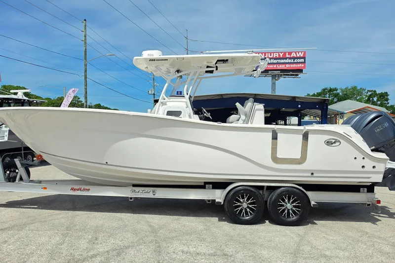 Slide: The Image of 2023 Sea Fox 288 Commander boat on trailer, displayed outdoors under clear sky. - 6