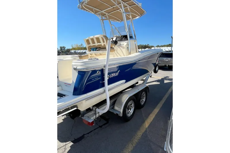 Slide: The Image of 2018 Scout 215 XSF boat on trailer, featuring a sleek blue and white design. - 2