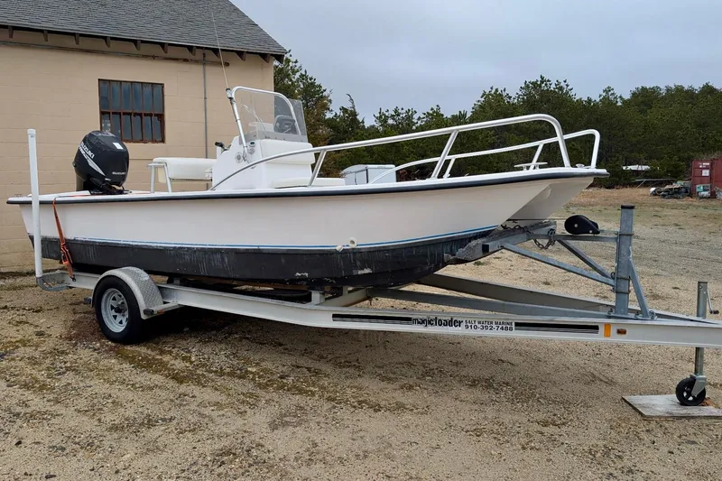 The Image of 2006 Twin Vee 19 BayCat boat on trailer, parked outdoors near a building. - 1