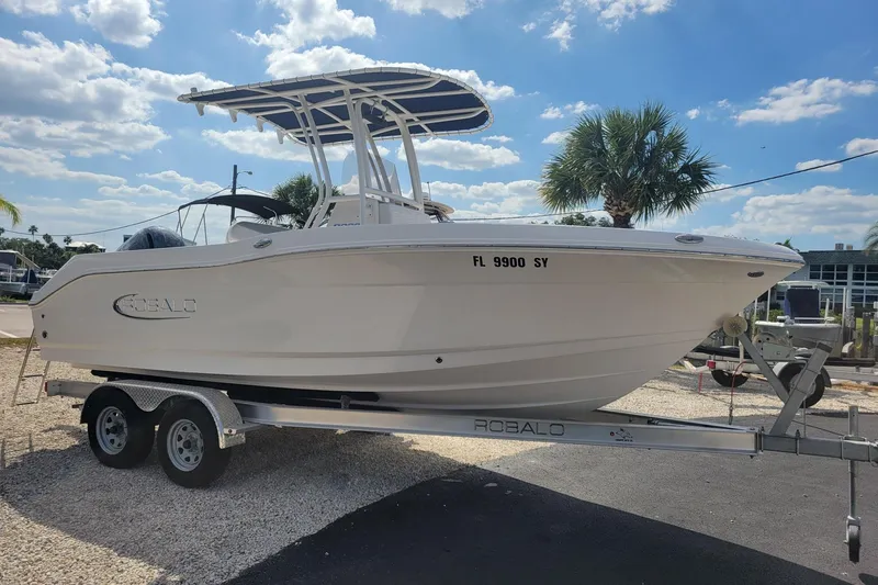 Slide: The Image of 2021 Robalo R200 Center Console boat on trailer, sunny day, palm trees in background. - 3