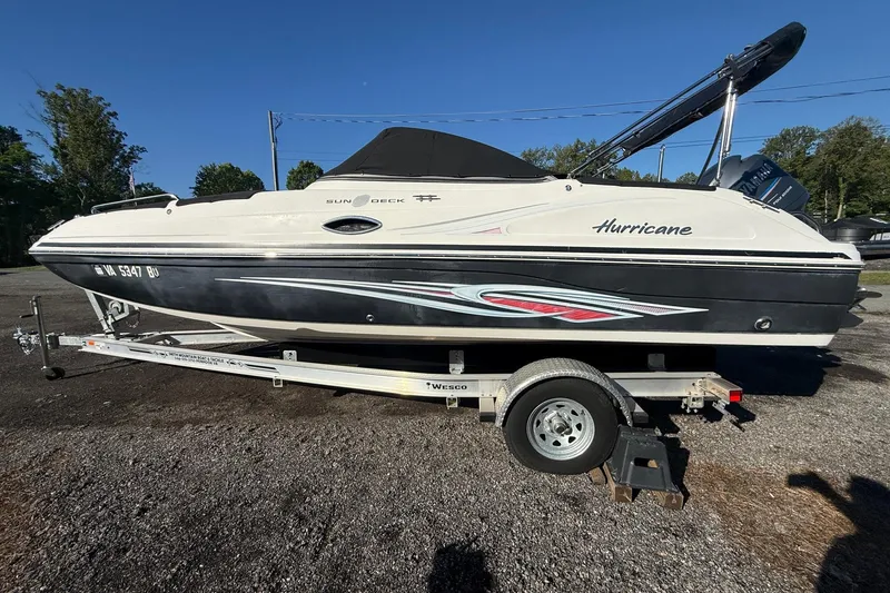 The Image of 2011 Hurricane SunDeck 217 OB boat on trailer, parked outdoors. - 0