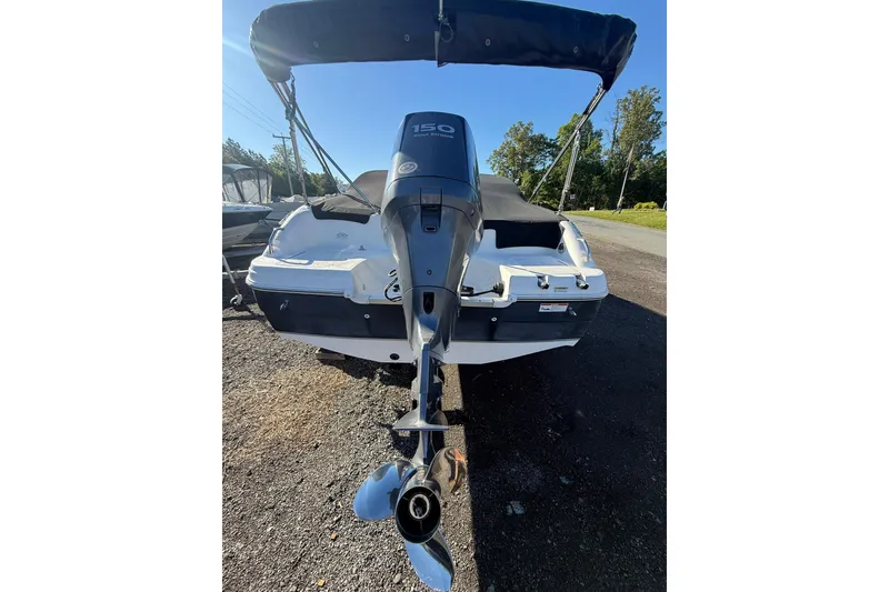 Slide: The Image of 2011 Hurricane SunDeck 217 OB boat with outboard motor, parked on gravel. - 3