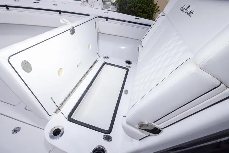 Slide: The Image of 2026 SeaHunter 33 Tournament boat interior with white cushioned seating and storage compartment. - 18