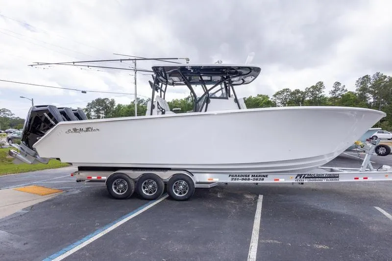 Slide: The Image of 2026 SeaHunter 33 Tournament boat on trailer, parked outdoors, showcasing sleek design and triple engines. - 22