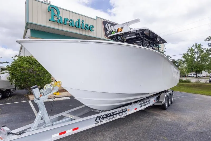 Slide: The Image of 2026 SeaHunter 33 Tournament boat on trailer outside Paradise store. - 26