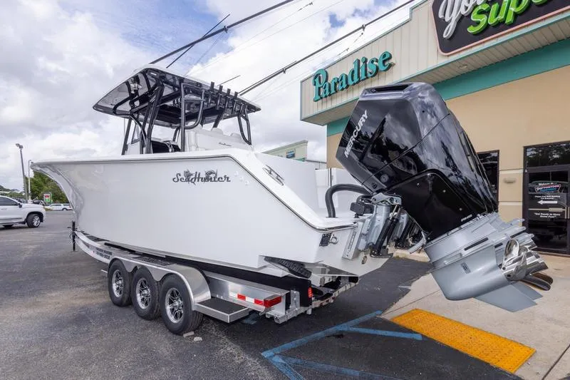 Slide: The Image of 2026 SeaHunter 33 Tournament boat with Mercury engine on a trailer outside a store. - 37