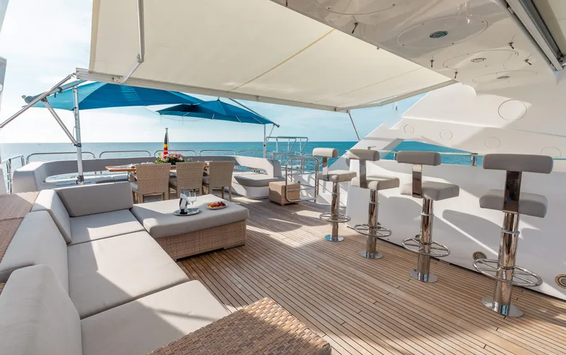 Slide: The Image of Luxurious deck of 2009 Sunseeker 121 yacht with seating, bar stools, and ocean view. - 7