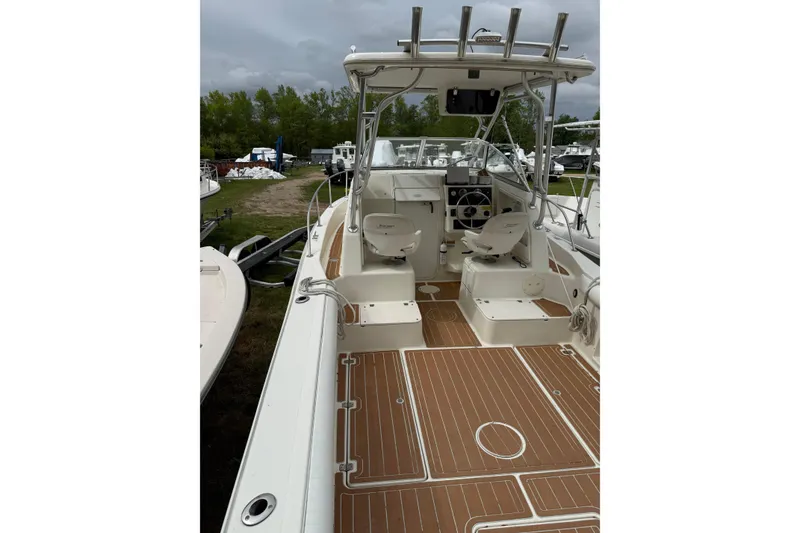Slide: The Image of 2002 Sports-Craft 261 boat interior with seating and steering console, docked outdoors. - 3