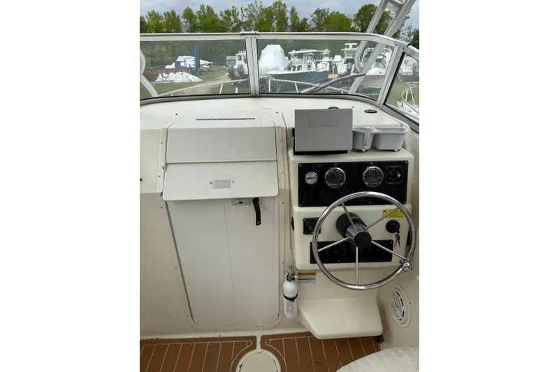 Slide: The Image of Helm of 2002 Sports-Craft 261 boat with steering wheel and navigation equipment. - 6