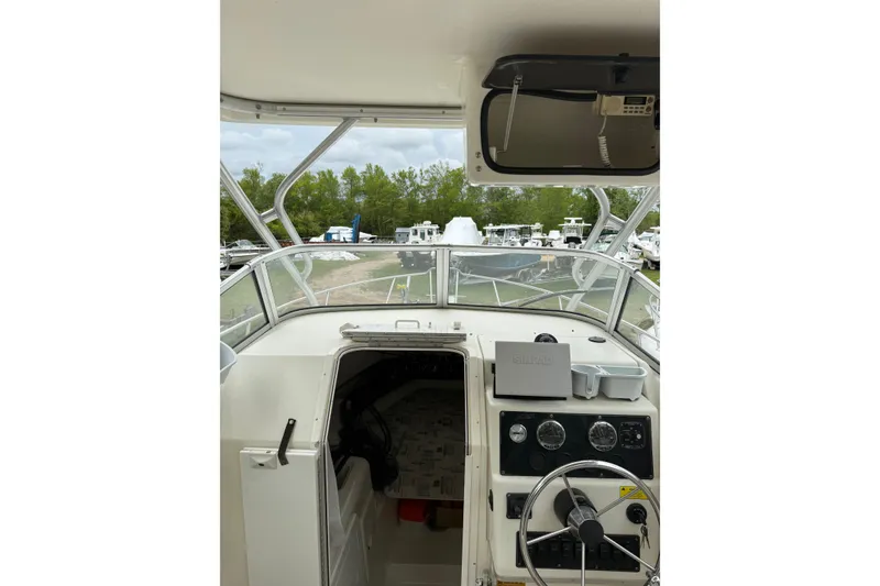 Slide: The Image of Interior view of a 2002 Sports-Craft 261 boat cockpit with steering wheel and controls. - 7